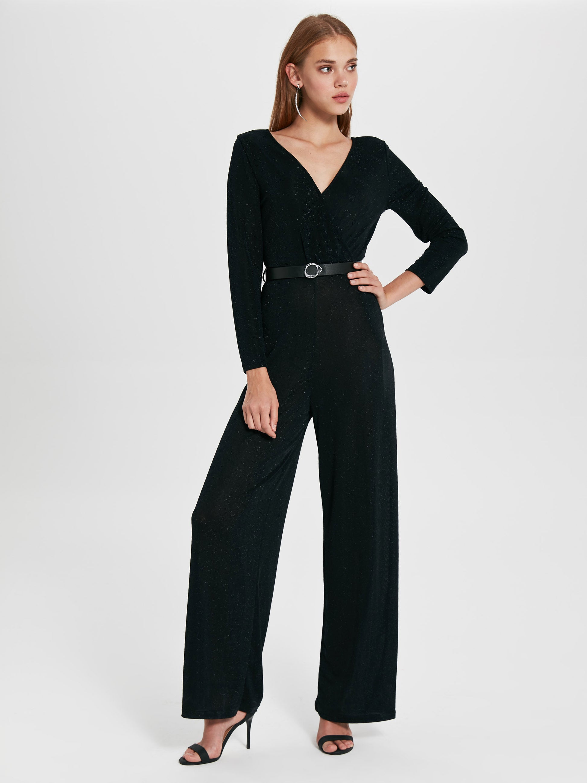 Eleganter Damen Overall mit hohem Bund, glitzerndem Stoff und transparenten Details, perfekt für besondere Anlässe.